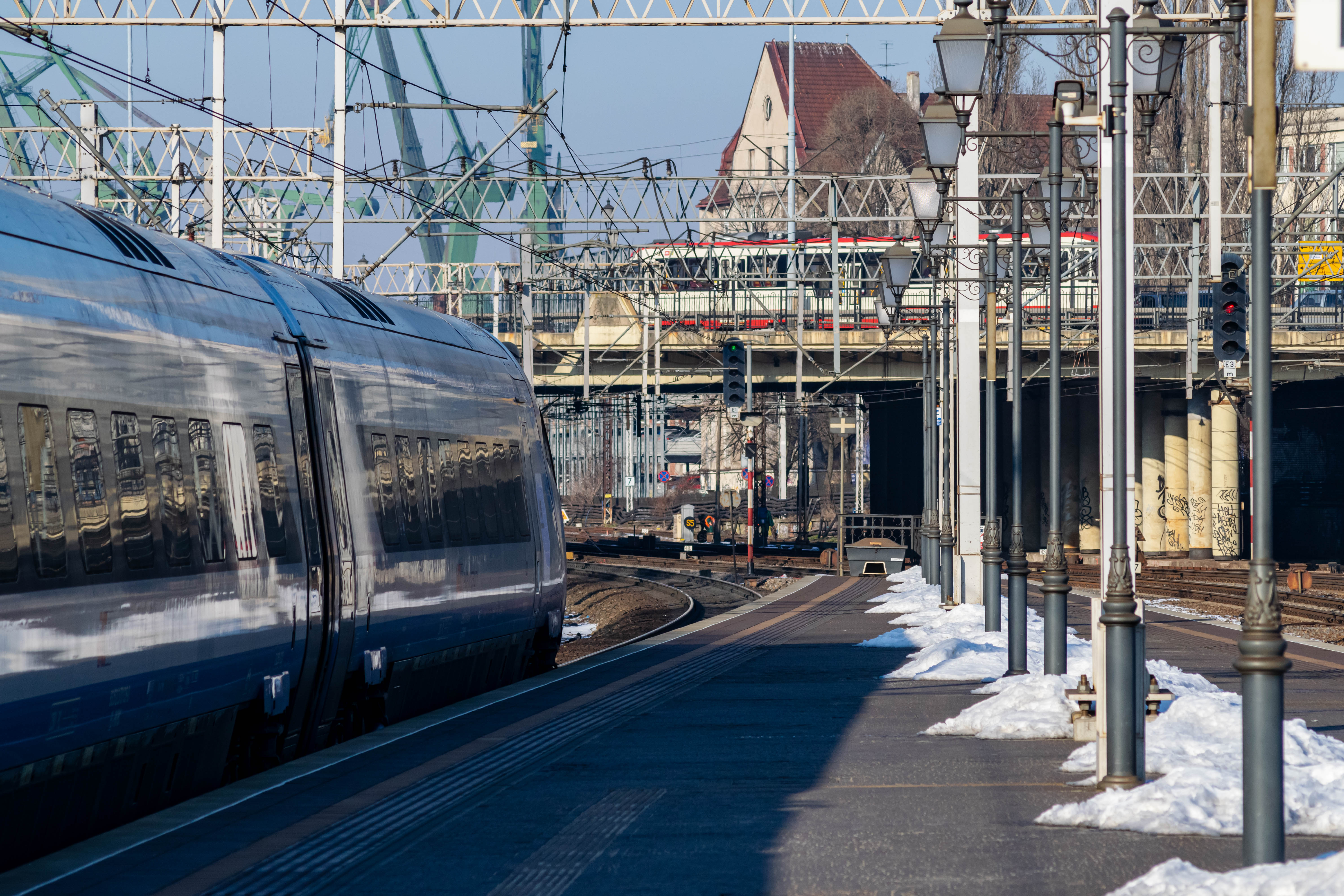 silver-blue train standing at a platform