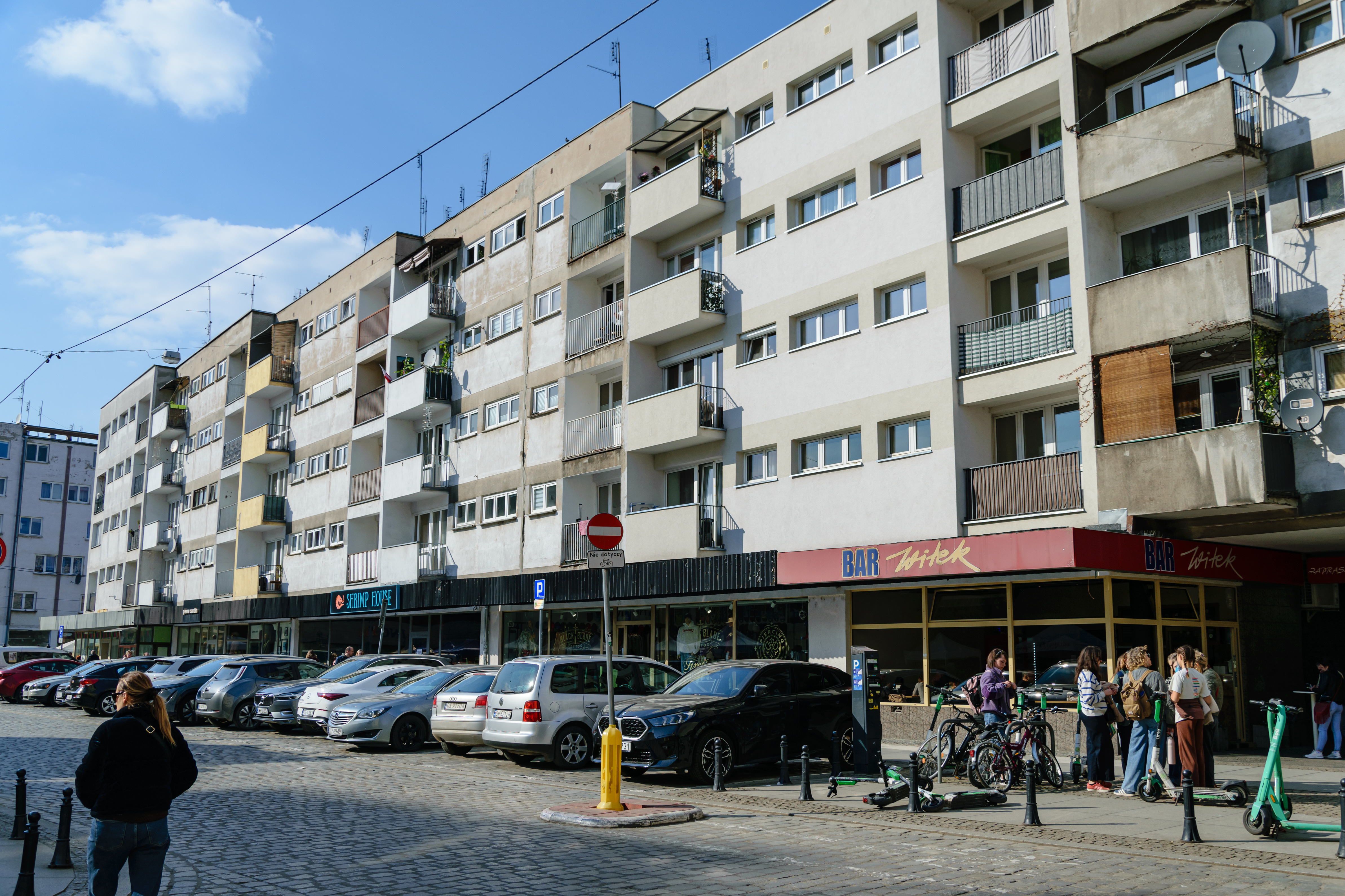 4-storey tall commie block with restaurants on ground floor