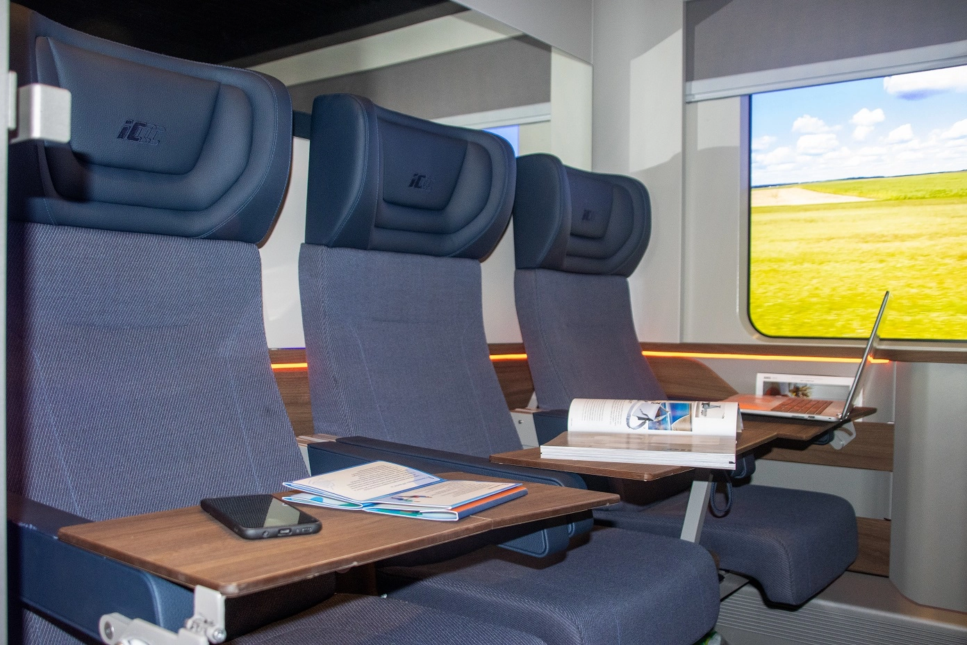mock-up of a six-seat second class compartment for new coaches of PKP Intercity, they have wooden accents and small tables for every seat attached to leather armrests, wooden accents and tables are missing from final form