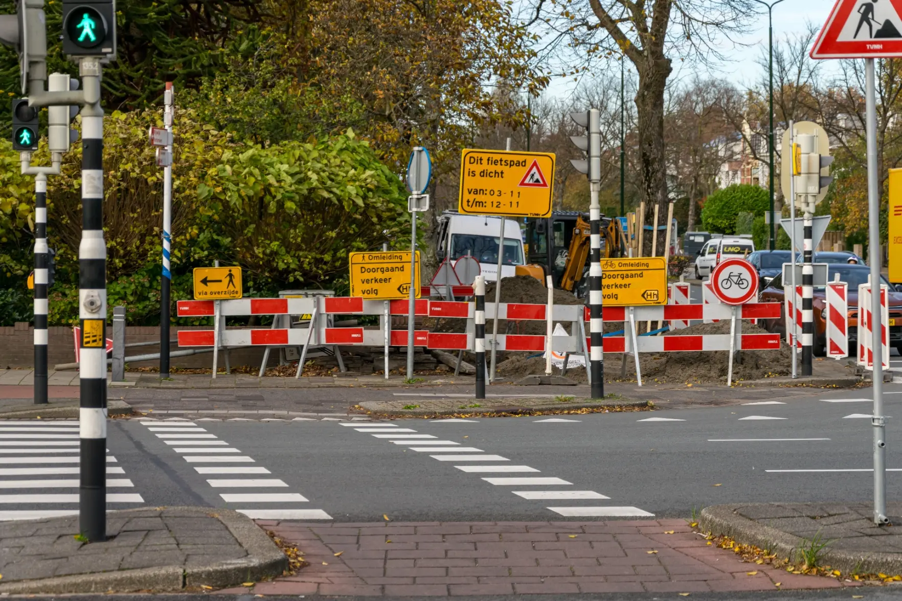 lots of yellow street signs pointing at a closure of this bike path