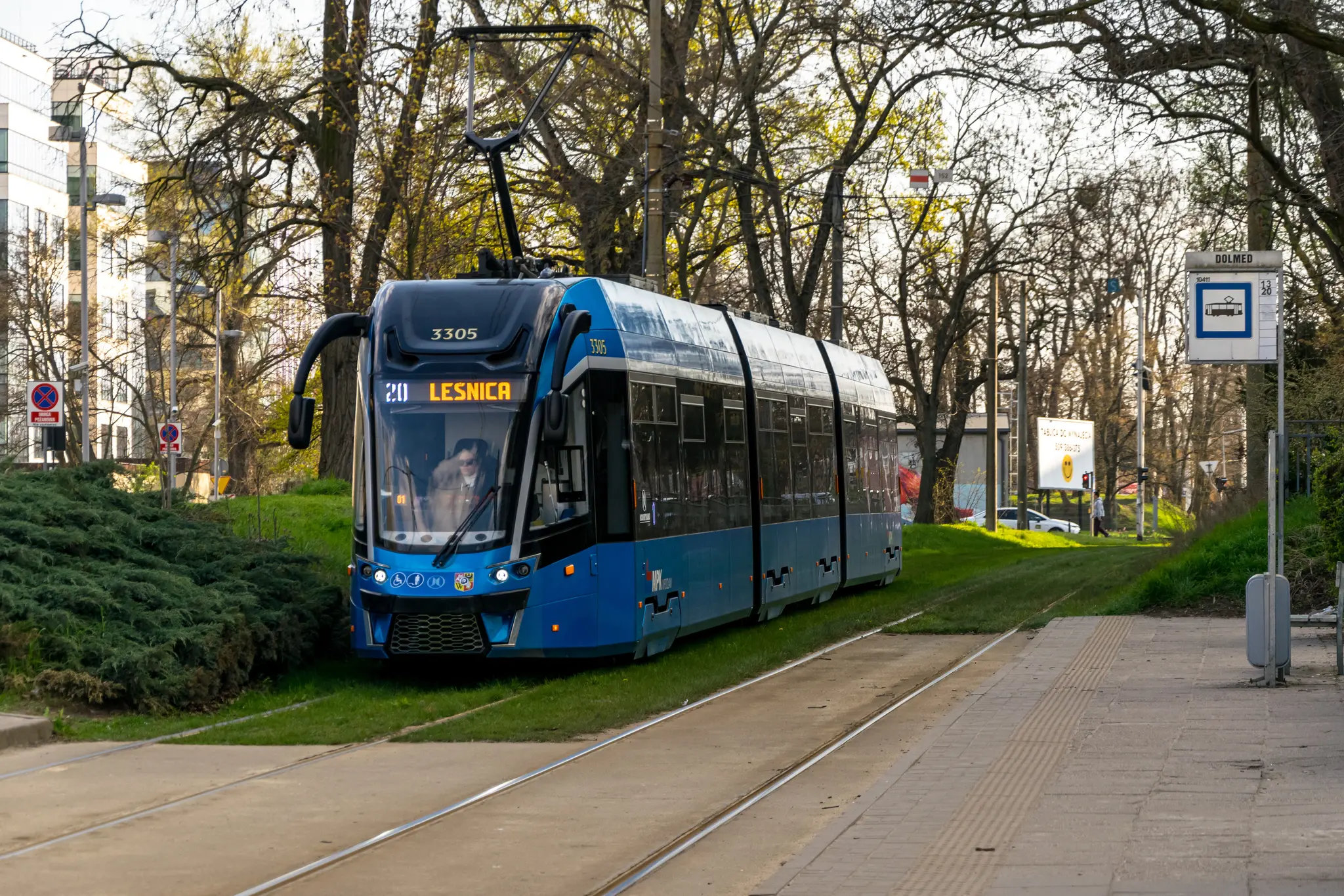 Light-blue tram entering a tram stop
