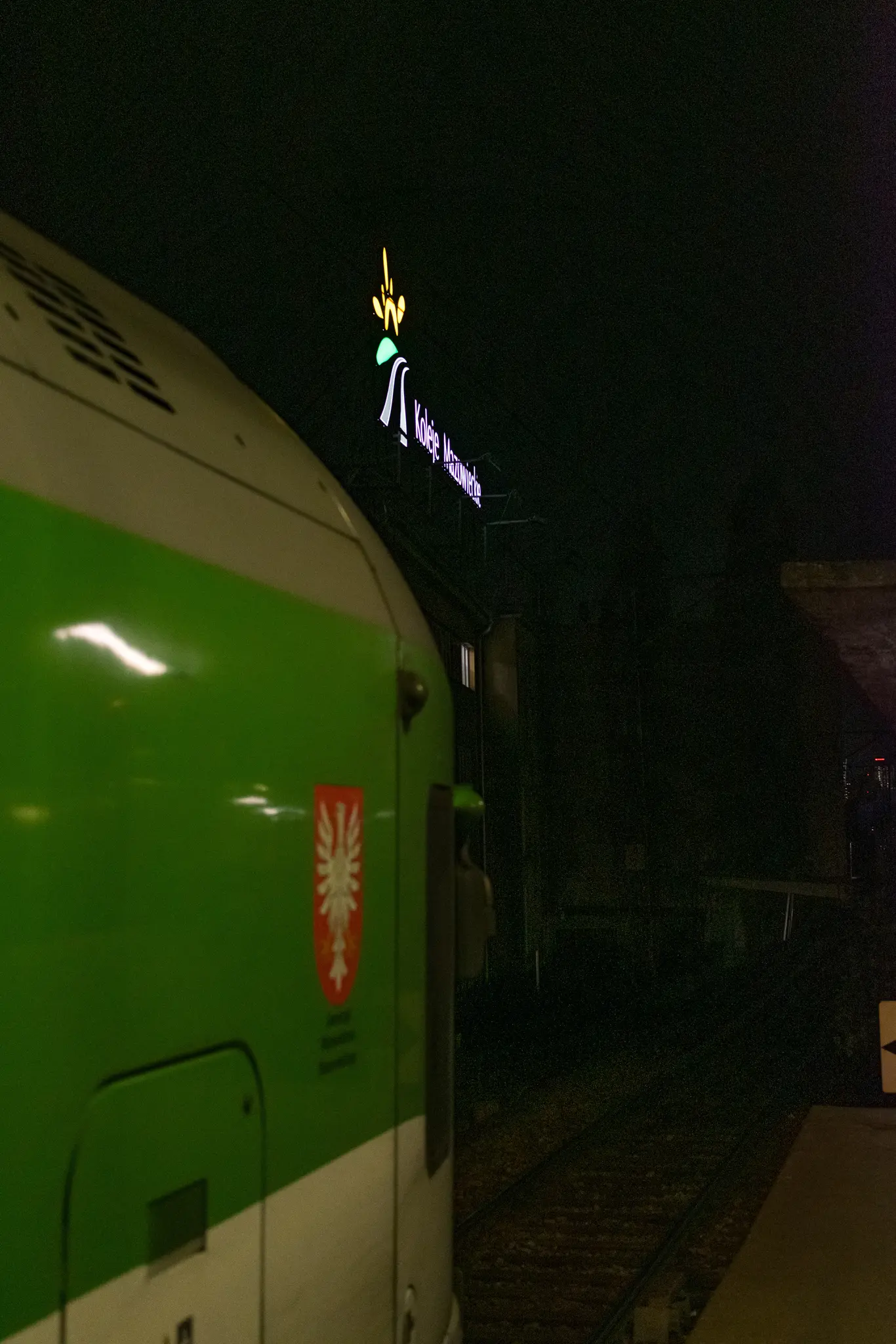 Angled logo of Koleje Mazowieckie on a building