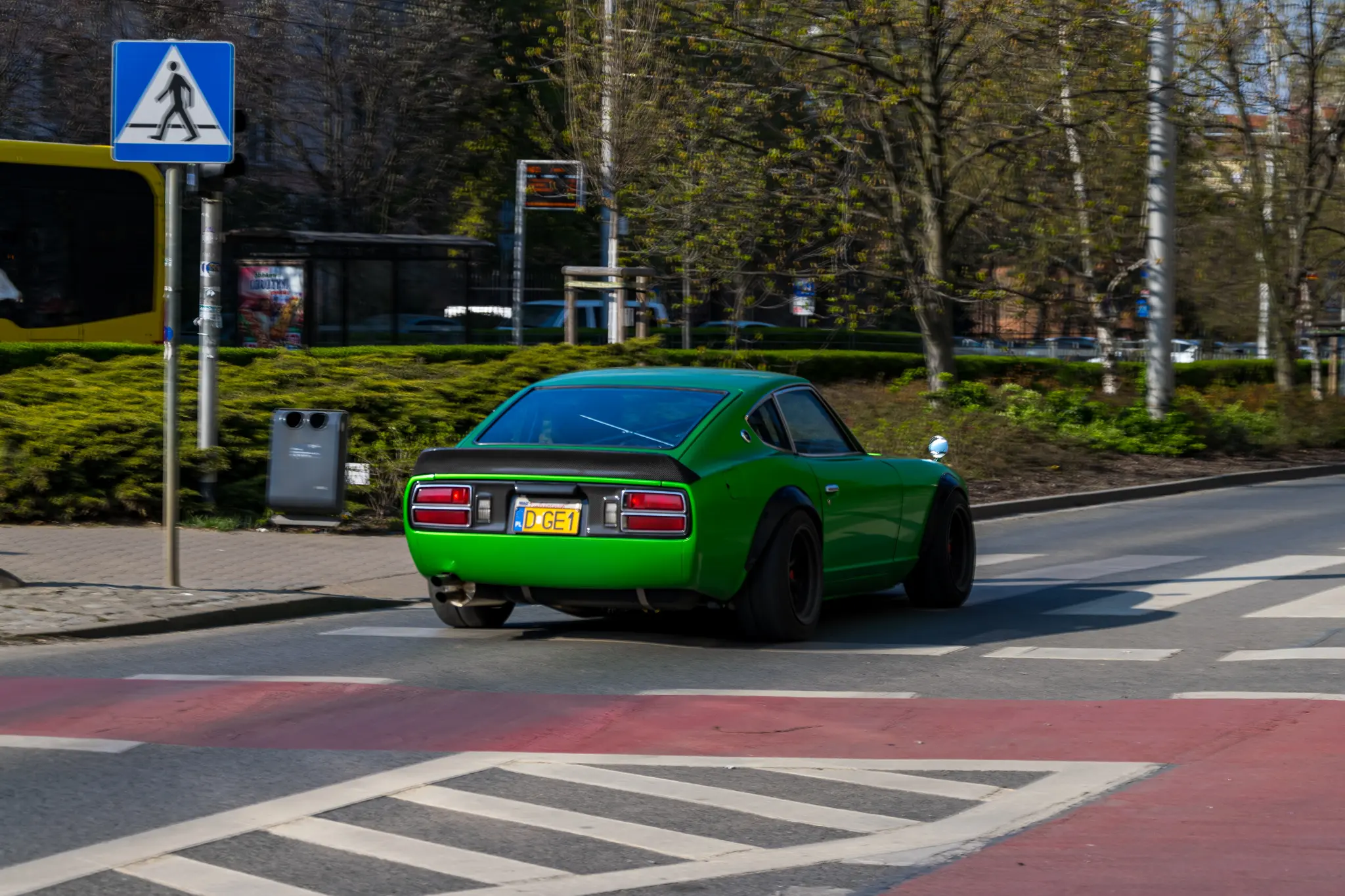 Green Nissan Fairlady Z (or Datsun 280Z, whatevers the name, it’s the same thing) sports car, with the blurred background of a random Wrocław boulevard