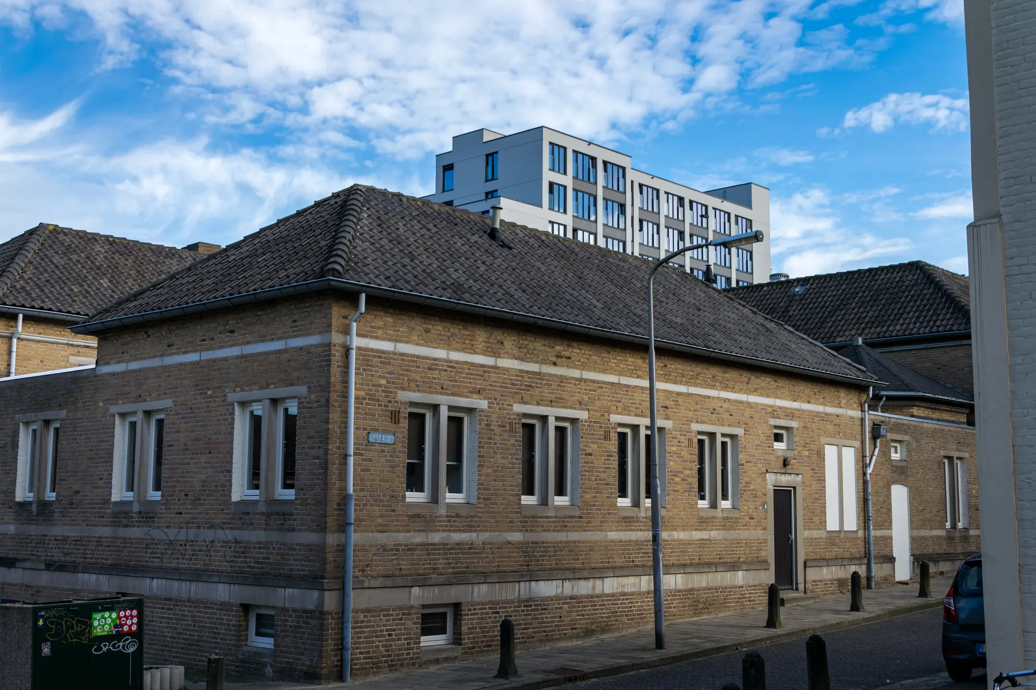 Old brick building with a modern residential (or office?) block in the background