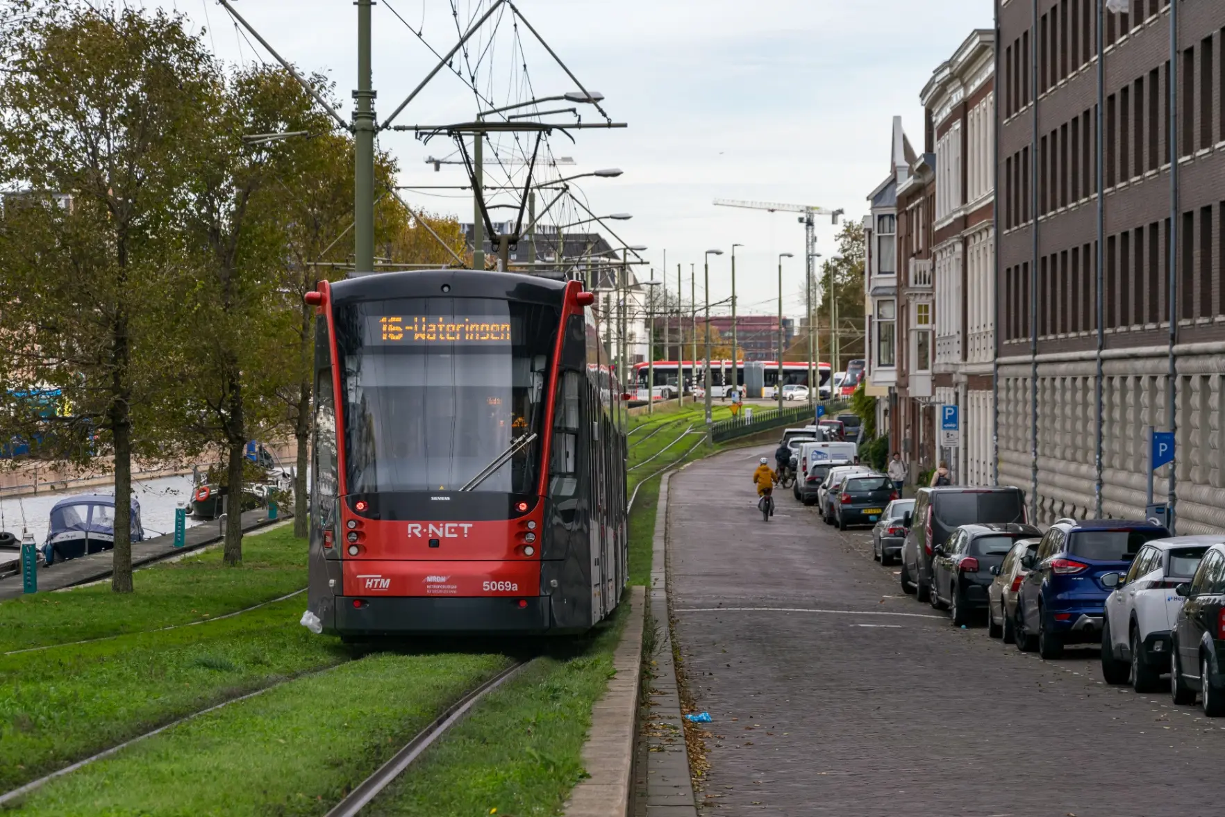 red-dark grey tram on grass tracks