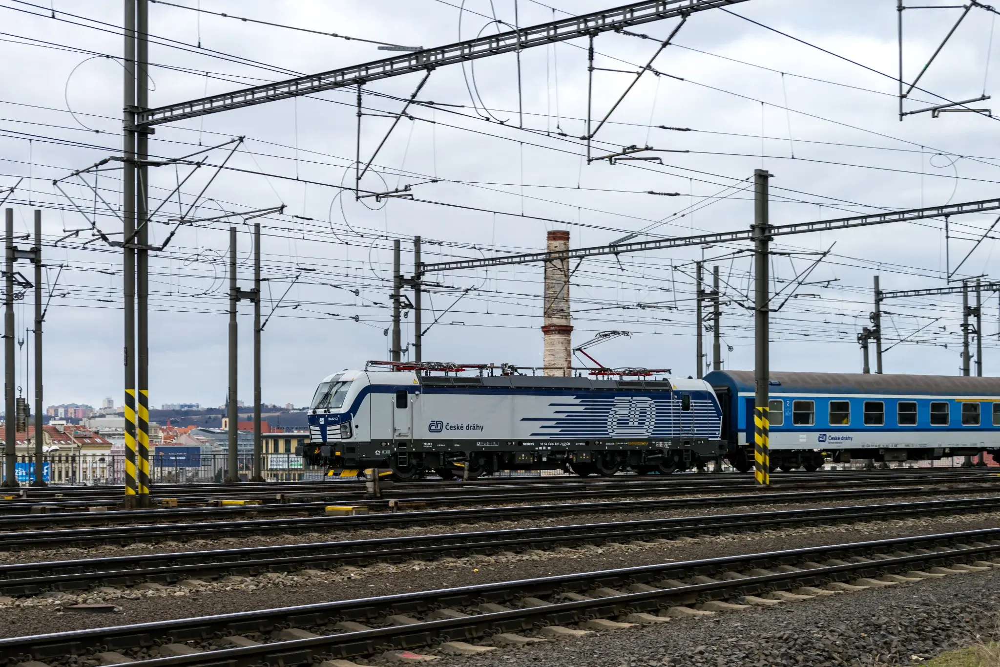 white-blue locomotive with blue stripes near the back, forming CD logo in white, with blue-white carriages
