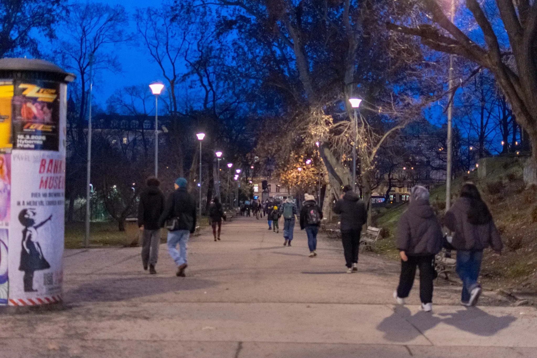 park full of people, most of them going towards a tram stop and city centre