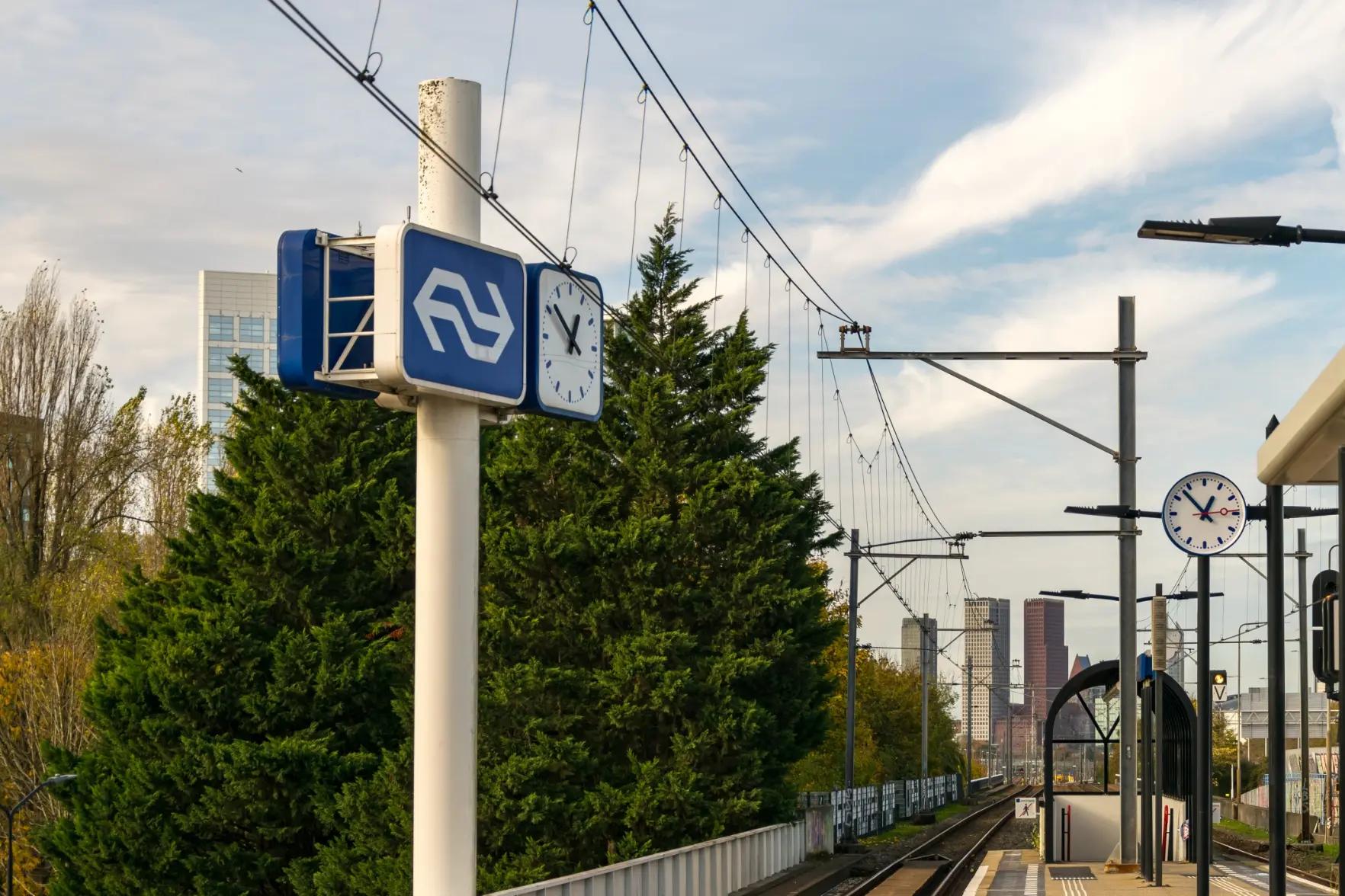 big ns sign on a pole, next to a stop