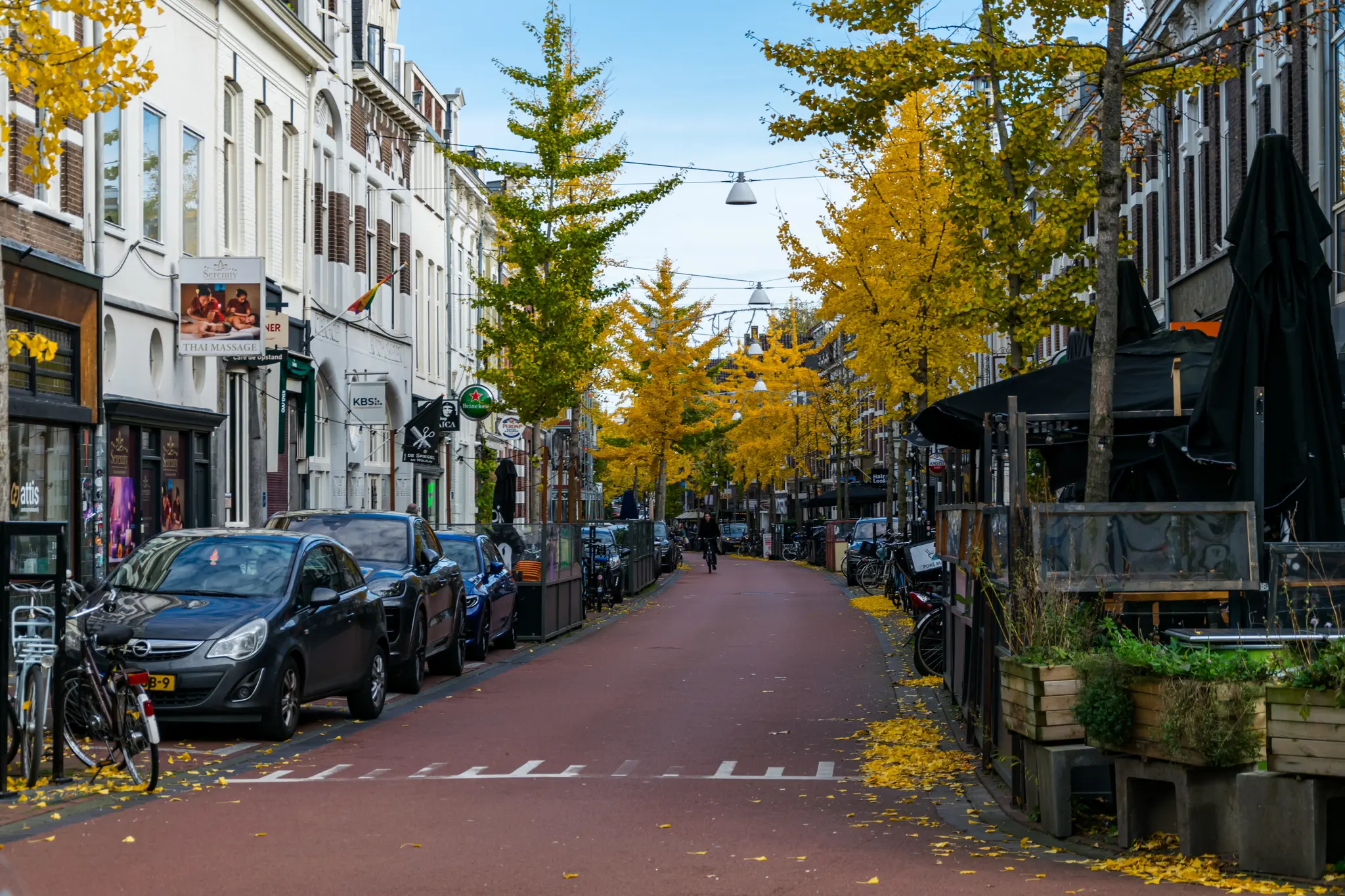 Narrow street with three/four-storey tall buildings, trees, parked cars and restaurant gardens in between, reminds me a lot of Poznańska in Warsaw🥴