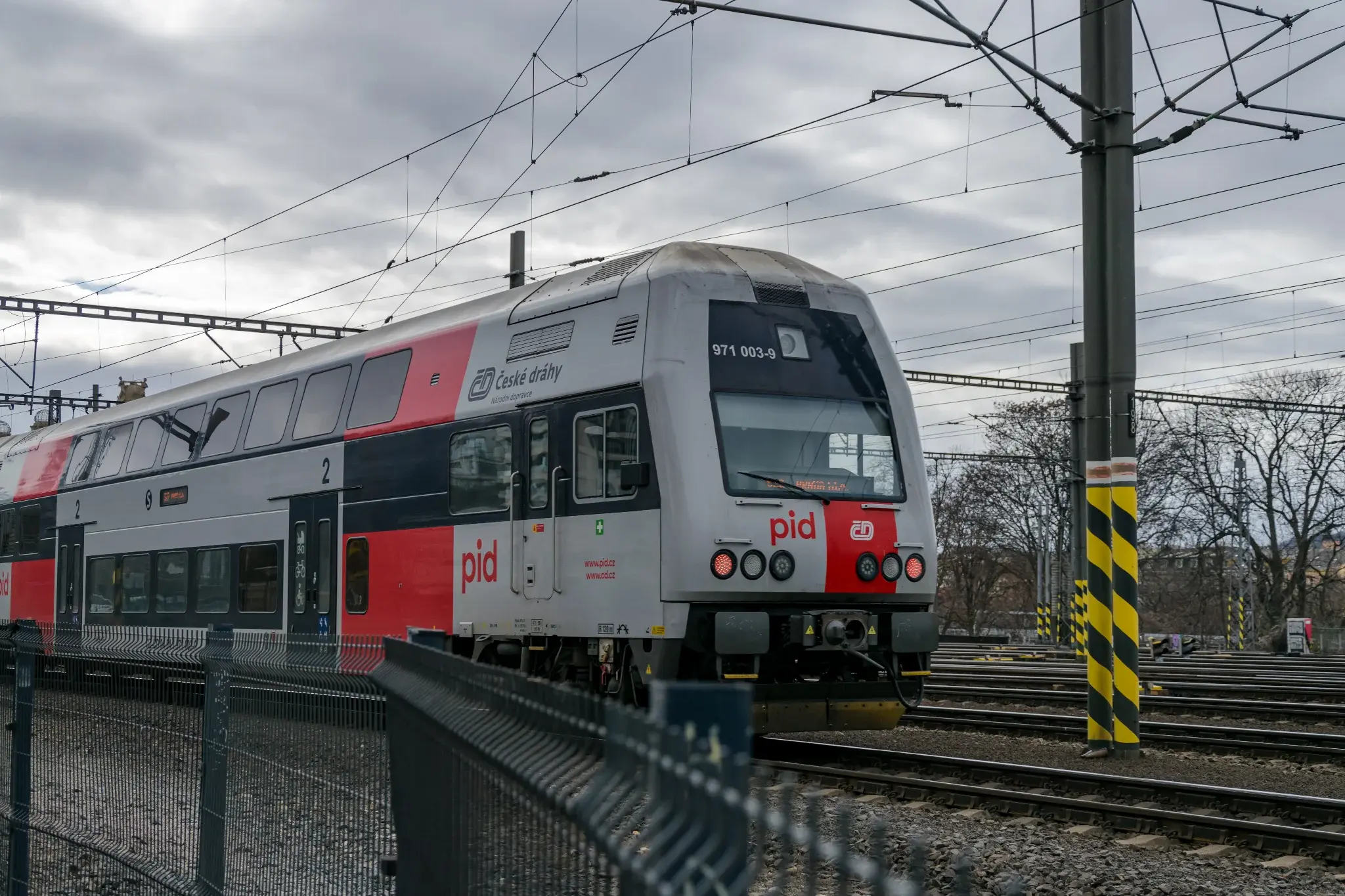grey-red double-decker train leaving the station
