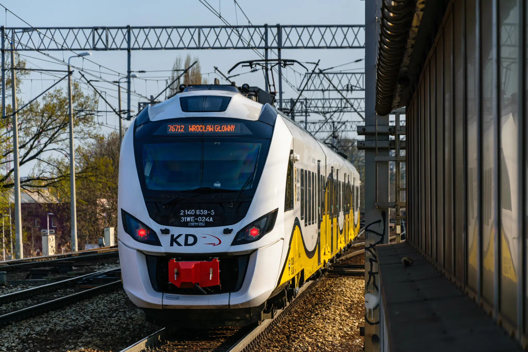 Yellow-white EMU leaving the station