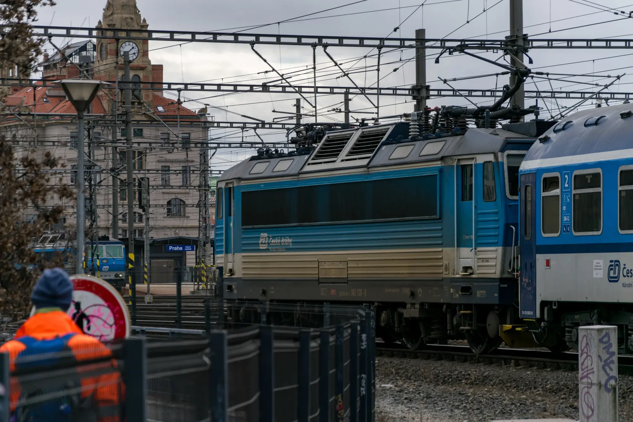 blue-white locomotive with blue-white coaches entering the station