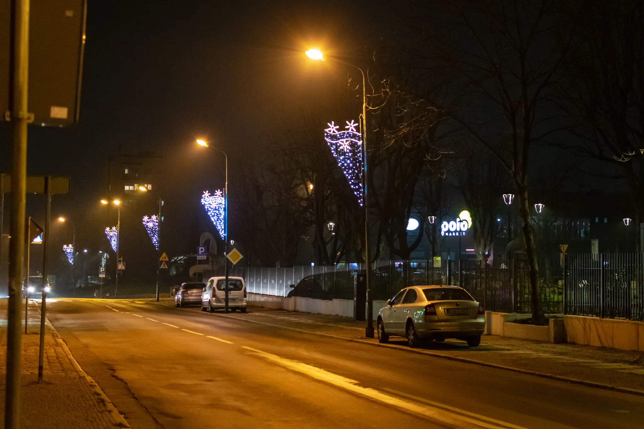 a street with sodium lights and christmas decorations put on them