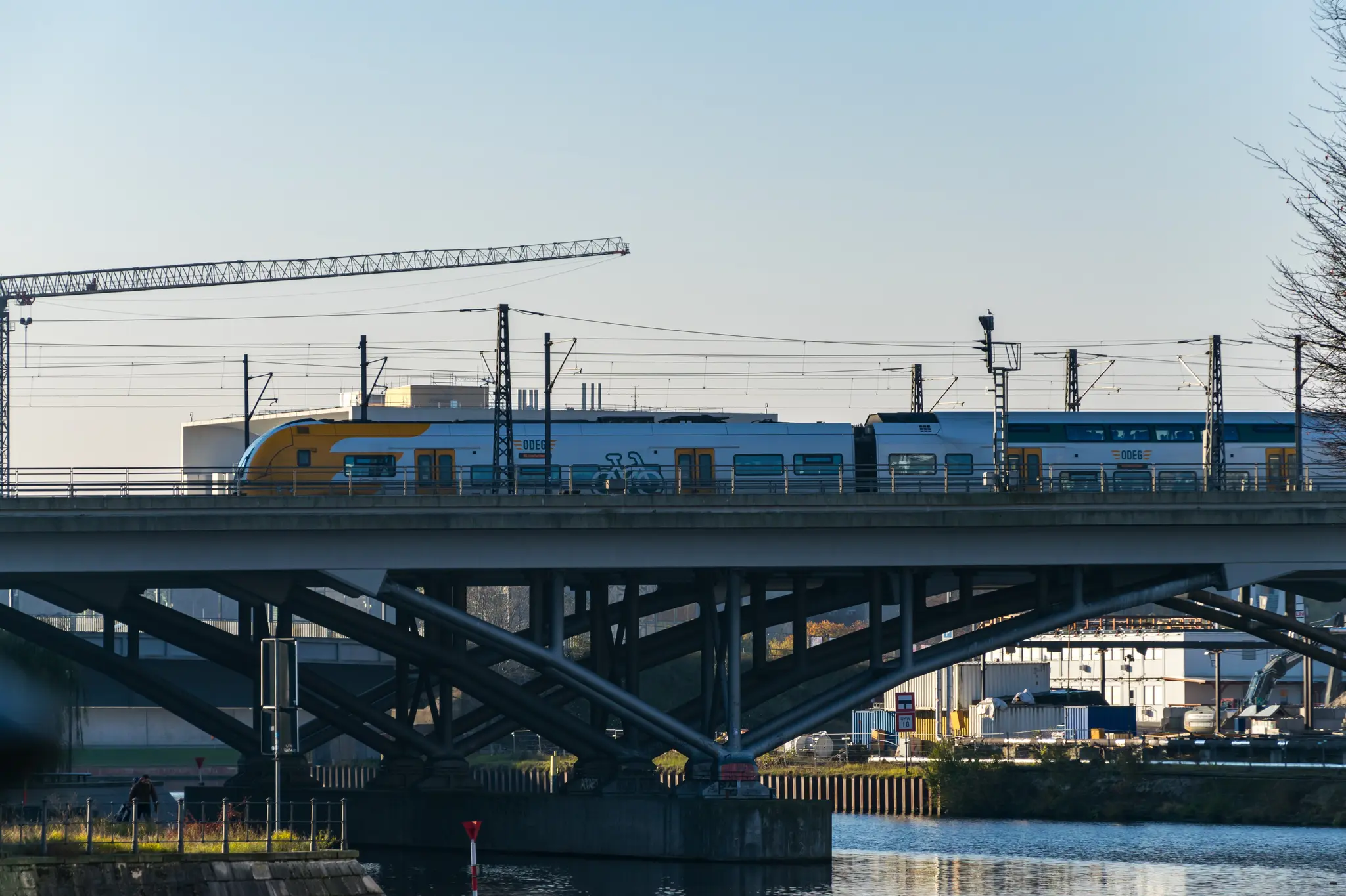 Orange-white train on a bridge, viewed from side