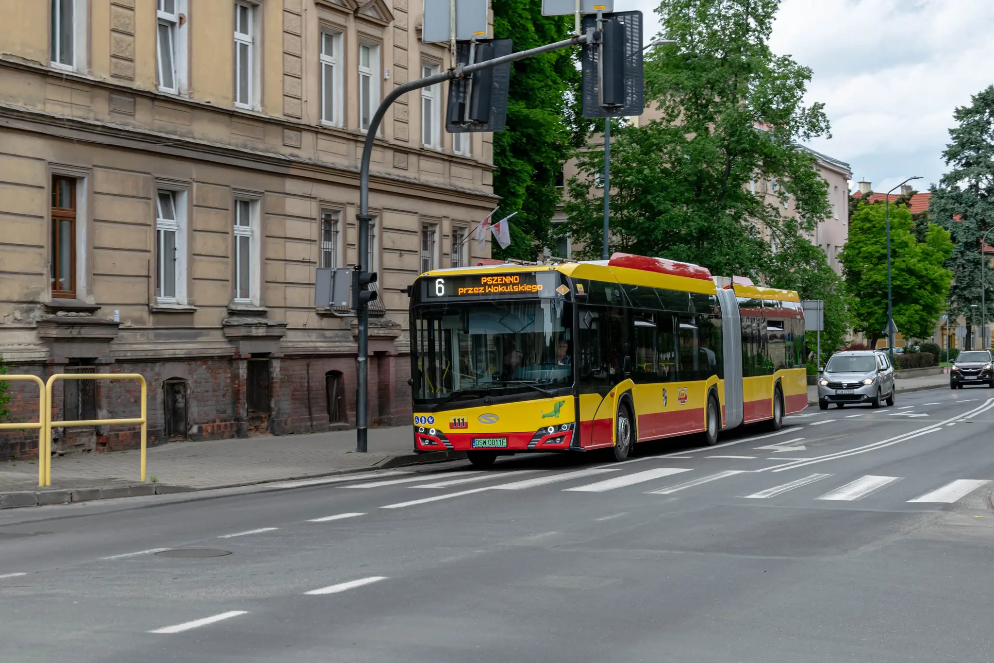 yellow-red bendy bus entering an intersection