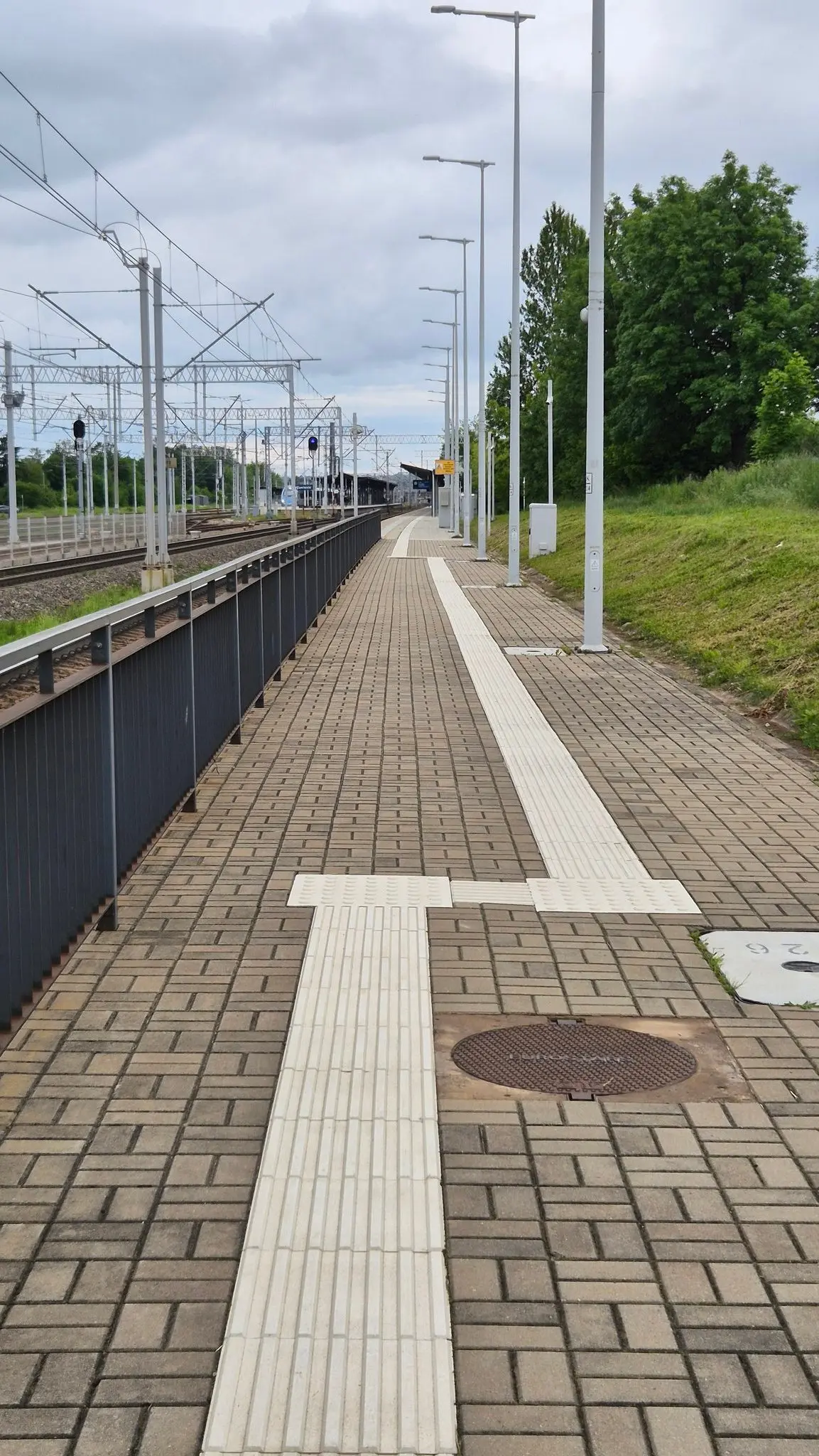 Prosty chodnik prowadzący do peronu kolejkowego z rowkami naprowadzającymi dla niewidomych.  W pewnym momencie z niewiadomych przyczyn rowki robią slalom i przez kilkanaście metrów prowadzą jakiś metr na prawo od miejsca gdzie były