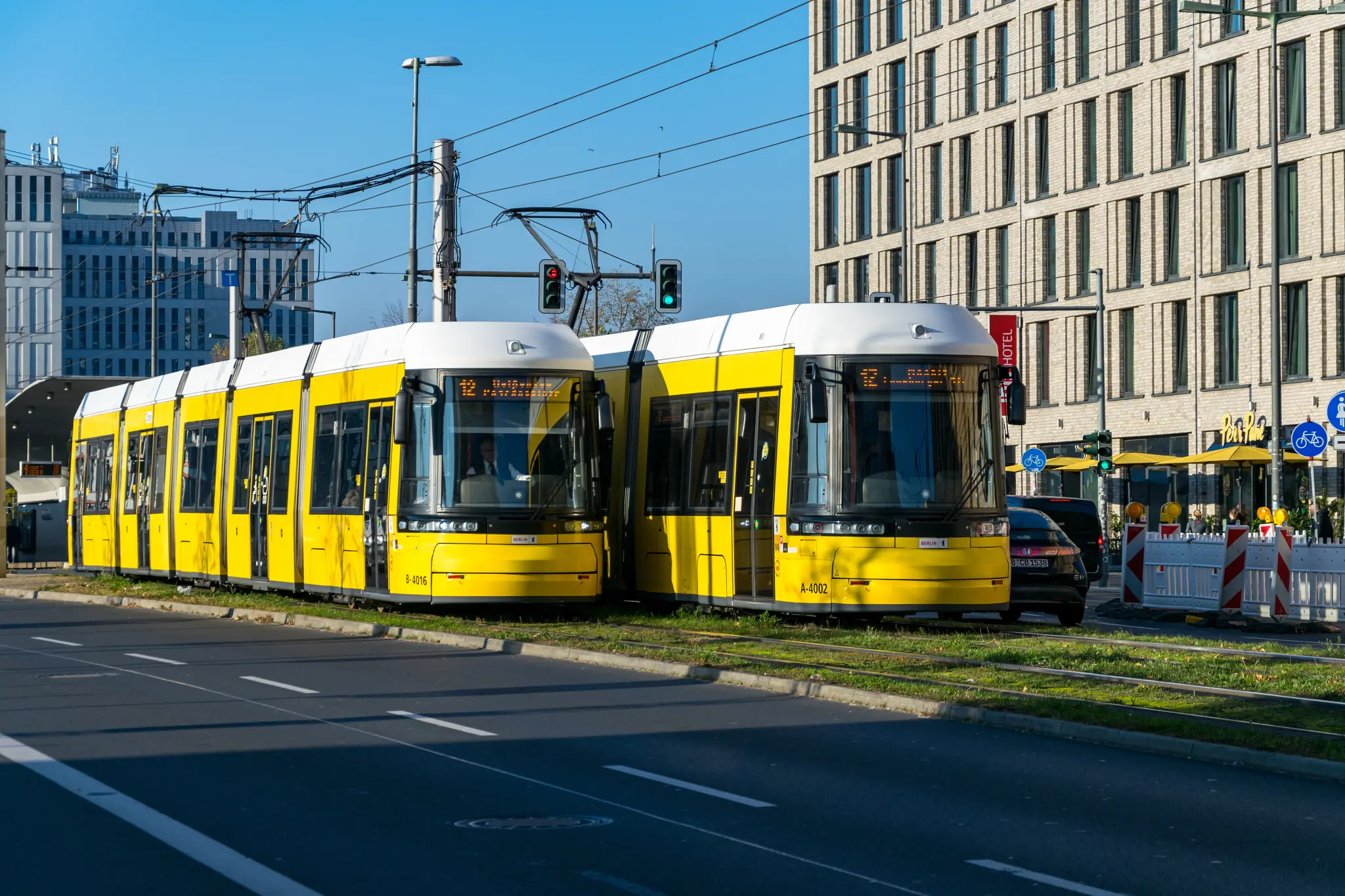 Two yellow trams on grass tracks