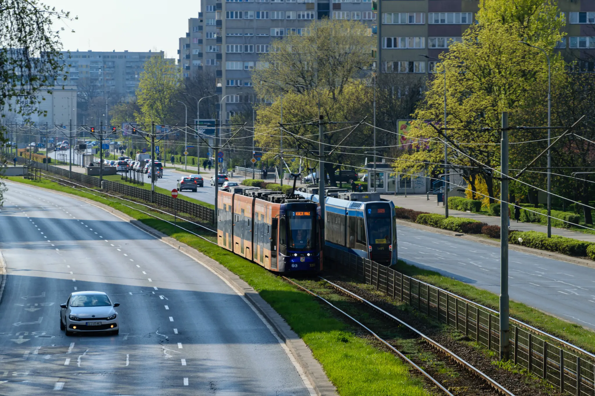 Light-blue and dark-blue trams on segregated tram tracks, left tram is a bit longer