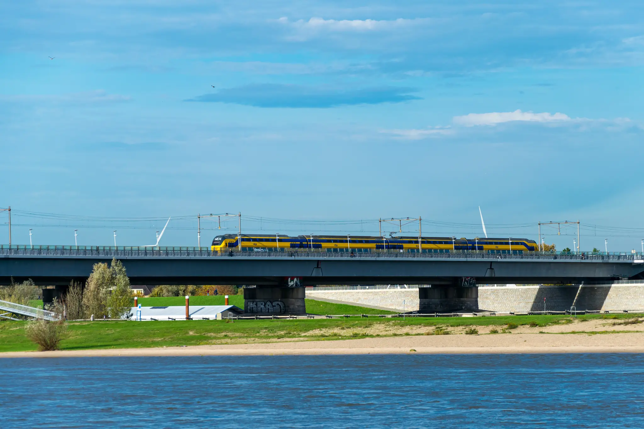 Yellow-blue double decker train on a bridge