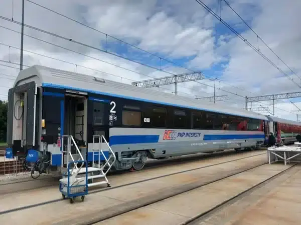 new coach for PKP Intercity, it's silver with black area spanning whole length of the coach around windows, and a wide-ish blue line at the bottom