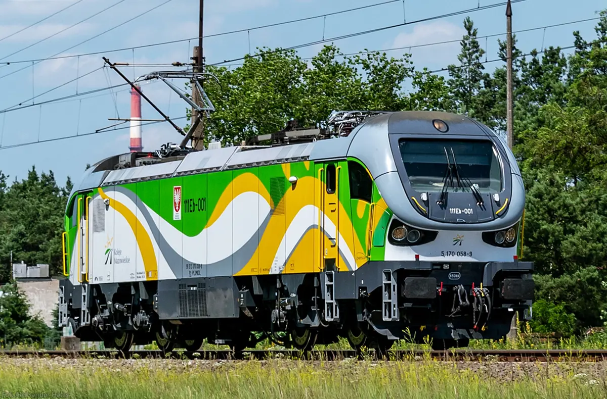 Electric loco in yellow-green-white wave-ish livery, using the same design language as the DMU