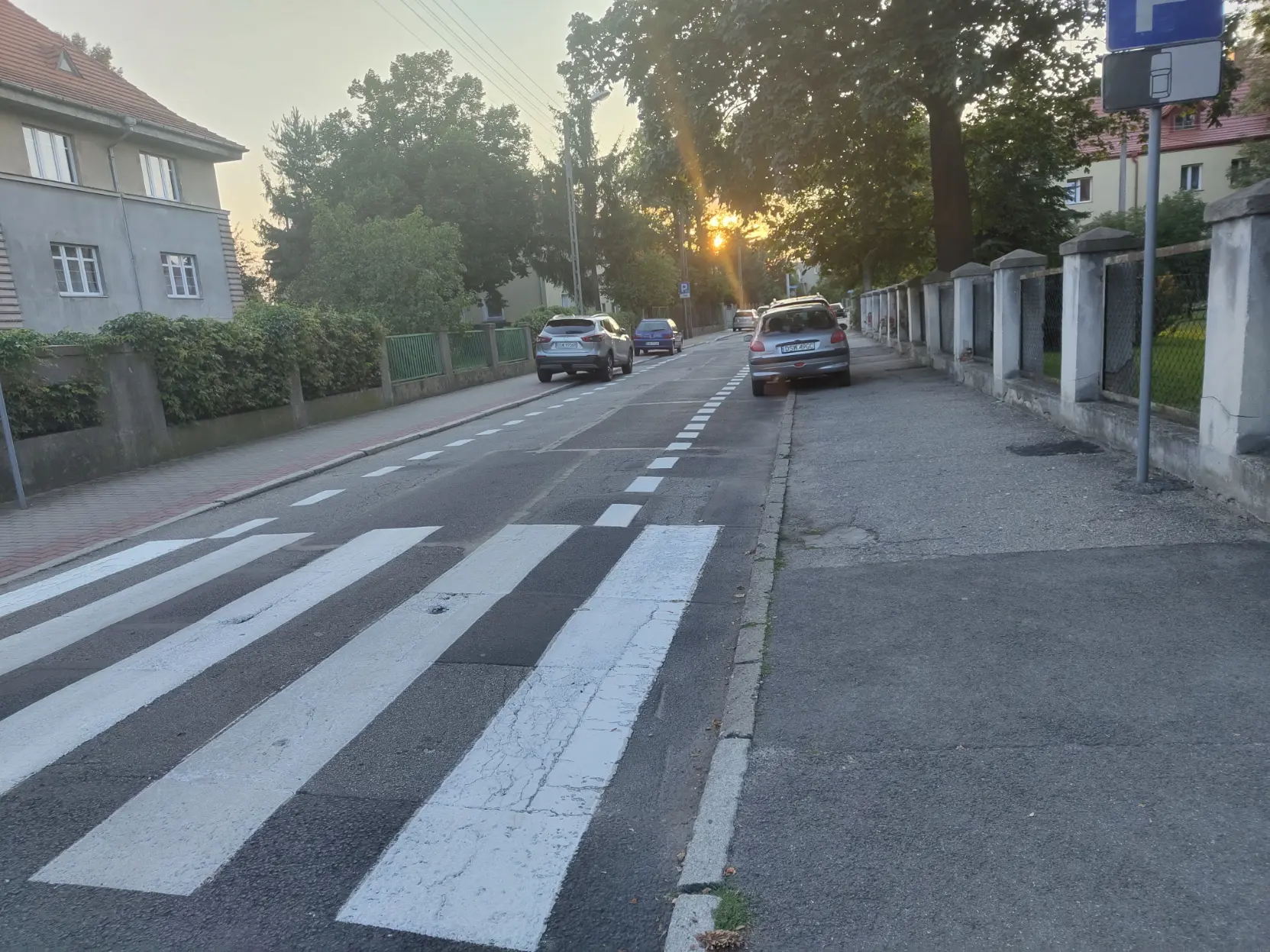 A narrow street that looks like it has bike lanes on the outside but it's just parking